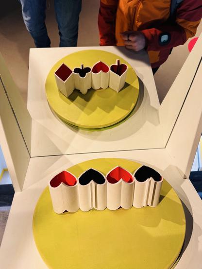3D shapes that looks like hearts when seen directly, but appear as card suits in the mirror
