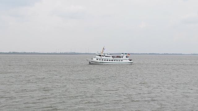 Die kleine, weiße Fähre nach Dangast muss in seiner engen Fahrrinne bleiben, um den Hafen Dangast sicher zu erreichen. Hier, bei Flut ist von der Rinne und dem Watt nichts zu sehen. Bei Ebbe ist da wo das Boot fährt fast kein Wasser mehr.