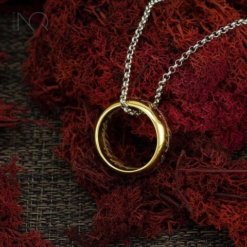 el mismo anillo de la foto anterior ahora colgando en una cadena plateada sobre los liquenes rojos