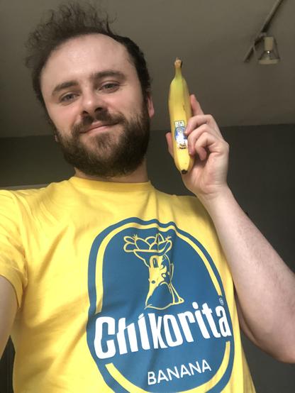 Me holding a chiquita banana and in a yellow shirt that says chikorita banana