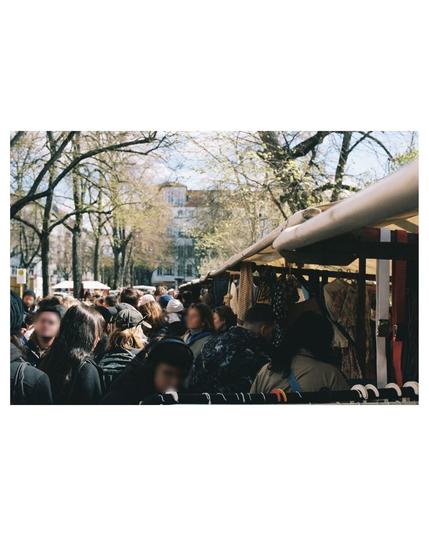 a big crowd of heads walking alongside the fleamarket on a sunny spring day.