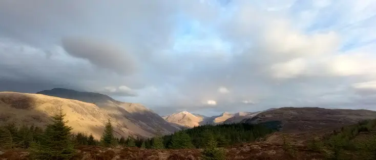 Mountains in a late spring sunshine. Ben Nevis on the left, in moody darkness, the summit hidden