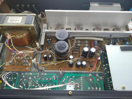 The inards of the amp. Dusty pcb's and lots of different sized capicitors.