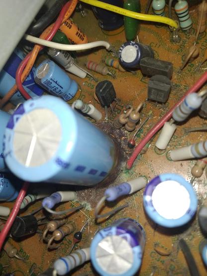 Again close up of light blue capicitors with brown goo and rust like stuff were they are placed on the pcb.
But more from above.