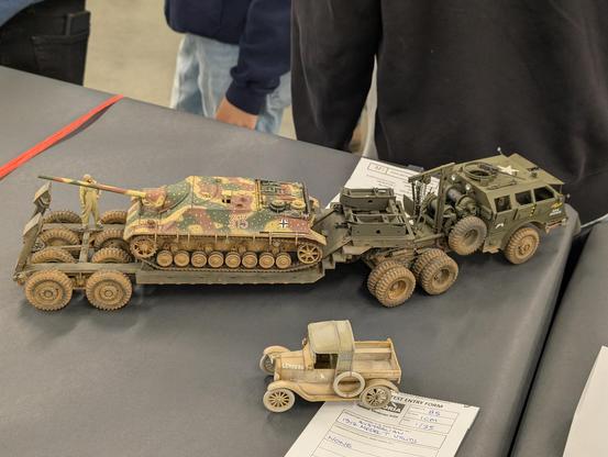 American military truck towing a German tank destroyer on a trailer.