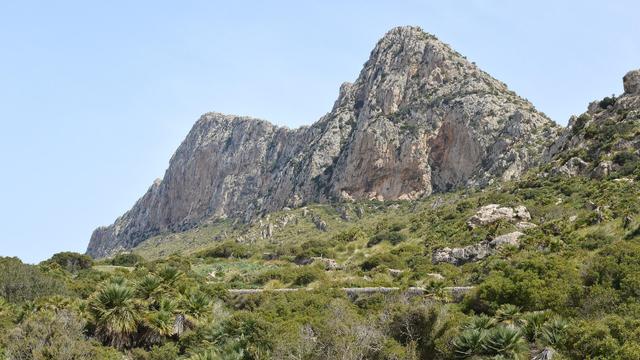 A photo of an arid mountain ridge. The sky is clear and blue.