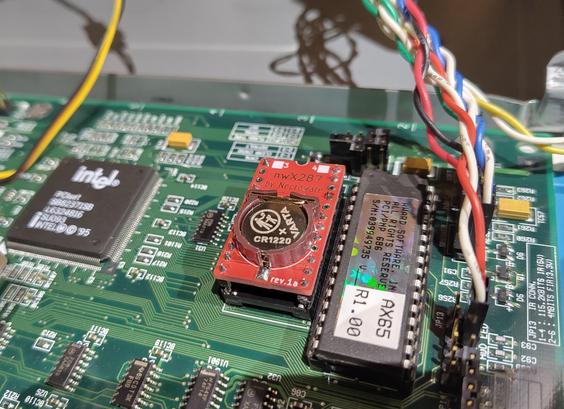 Close-up picture of a corner of a Pentium Pro motherboard.
On the motherboard, in place of the battery-integrated, a small red PCB is socketed.