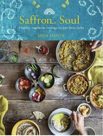 "Indian blue" cover with indian style patterns. Picture of wooden table with a number of Indian dishes and bowls of ingredients. Yellow and white text.