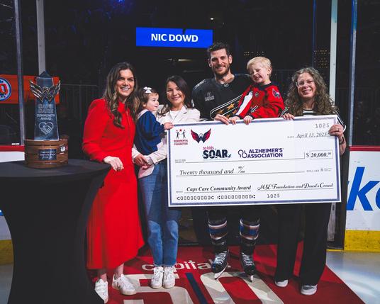 Nic Dowd is presented with a $20,000 check from Monumental Sports & Entertainment Foundation that will be split evenly between So Kids Soar and The Alzheimer's Association National Capital Area Chapter in tonight's Caps Care Community Award pregame ceremony.