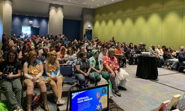 A view from the stage of the audience attending the C2E2 panel “The Horror that Made Us”; the room is filled with folks seated and also standing in the back, numbering around 100; photo credit: Brian Pinkerton