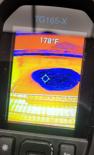 Blue object, flat, on a orange hot surface inside what appears to be a stove, like the Predator is looking at a pizza