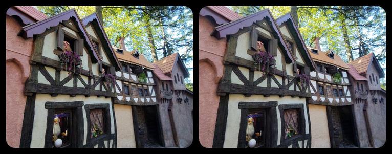 Windows in half-timbered buildings with talking animatronic heads, Old European Village, Enchanted Forest. Below them, at ground level is a fortune-telling machine featuring Mondor the Wizard.