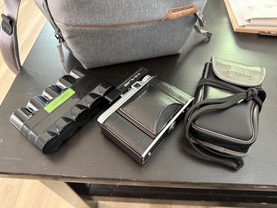 A film holder full of 120 film, a Voightlander Perkeo folding camera with a rangefinder on it, and a light meter