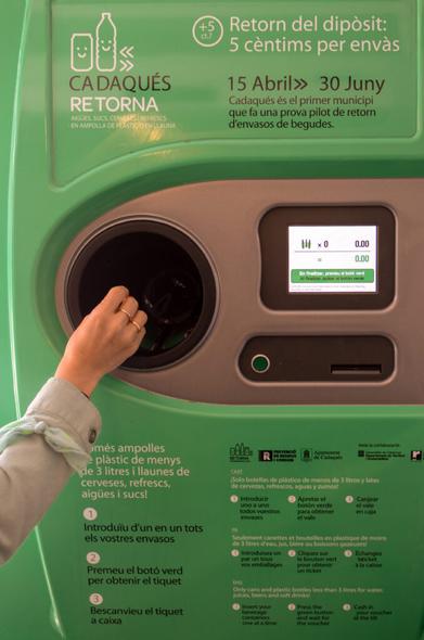 Una persona deposita un envase vacío en una máquina de un sistema de depósito, devolución y retorno de envases (SDDR).