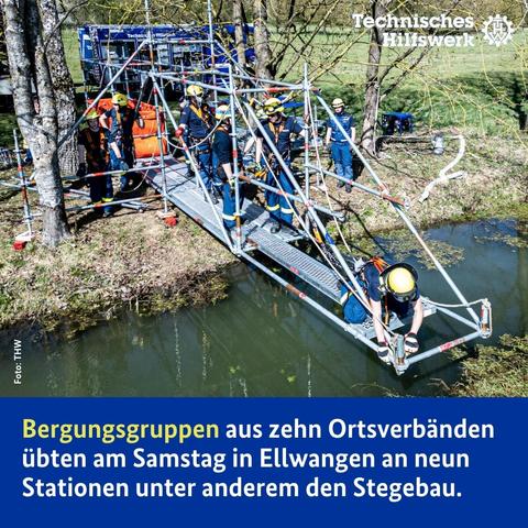 Einsatzkräfte errichten einen Steg aus Metallteilen über einem Gewässer.