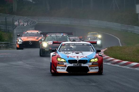 Brightly painted racing cars coming up a hill toward the camera