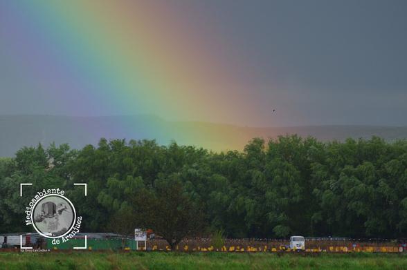 base de un arco iris sobre una huerta de Aranjuez en la vega del río Tajo, contraste del arcoíris con el verde de la huerta y cielo gris