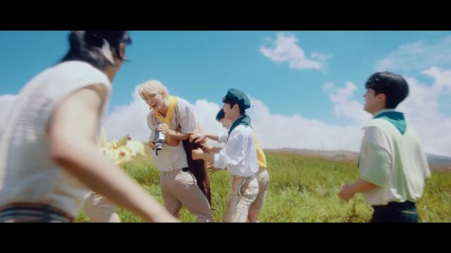 Bang Chan hoists Felix over his shoulder with his arms around Felix's waist. Han, Seungmin and I.N are either helping or interfering. Hyunjin and Changbin are watching.