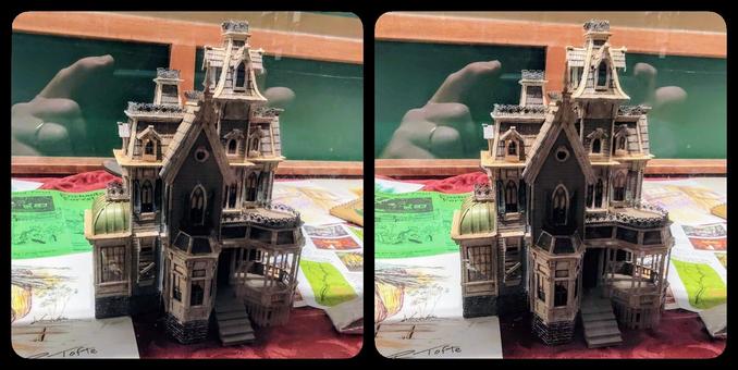 A model in a display case of a Victorian haunted house.