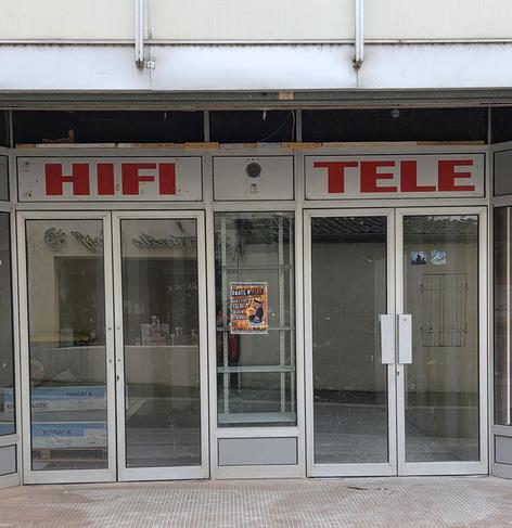 Two sets of glass doors surrounded by brushwd aliminium. Above one an allcaos typeface in red says 'HIFI" above the other "TELE"