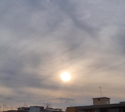 Nel cielo grigio, il sole esce a farsi vedere durante il tramonto