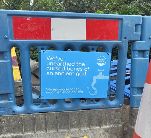 Photo of a Thames Water roadworks sign that says "We've unearthed the cursed bones of an ancient god"