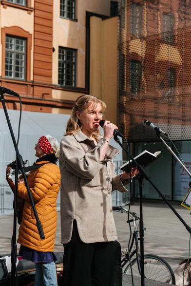 A protester is giving speech using the microphone on stage.