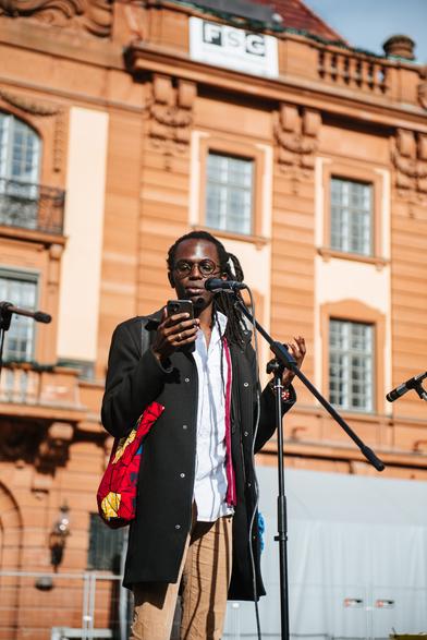 A student protester from the university is giving a speech in English.