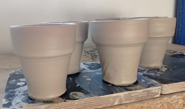 Fitting cups just after throwing. White stoneware ceramics. Pictures show that the seven cups are very similar in dimensions which should permit good fit