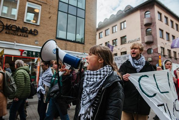 Greta Thunberg on megaphone and we can see protesters all around her.