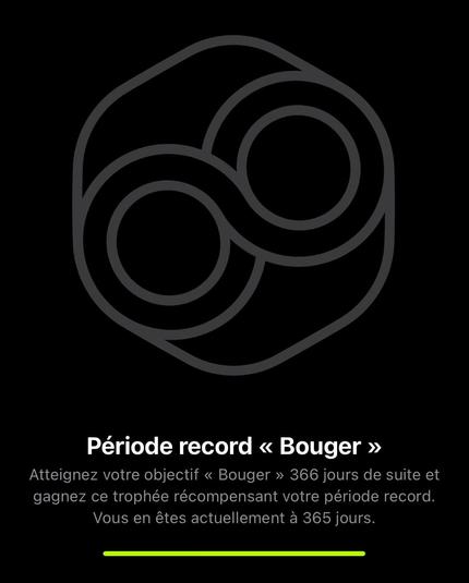 Badge « bouger » inactif, gris sur fond noir. La légende : atteignez votre objectif « bouger » 366 jours de suite et gagnez ce trophée récompensant votre période record. Vous en êtes actuellement à 365 jours.