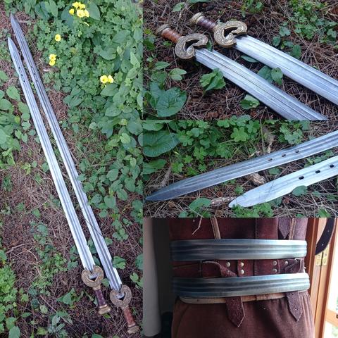 Último collage de fotos de producto de las piezas terminadas: ambos cinturones estirados sobre la hierba vistos desde arriba y a la sombra; foto de medio lado desde las hojas/correas a las empuñaduras/hebillas sobre la misma hierba; foto en el mismo detalle pero con las puntas de las hojas/correas en primer plano, y ambos cinturones puestos al maniquí con armadura de cuero ligera, pero esta vez la parte posterior para mostrar los efectos de luces y sombras del metalizado de las hojas/correas y los relieves