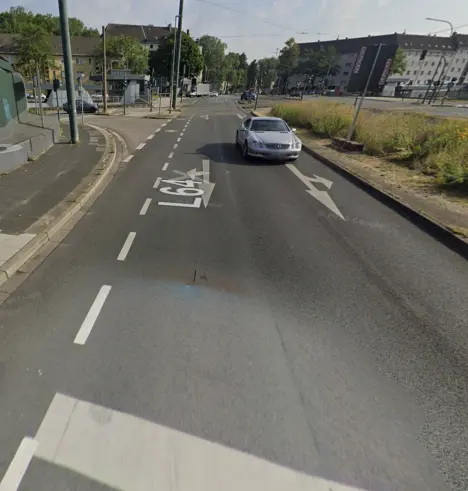 zweispurige Hauptverkehrsstrasse  mit einem Fahrradschutzstreifen, durch unterbrochene Linie vom Fahrstreifen abgegrenzt