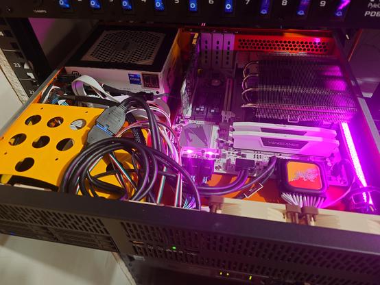 View inside server, messy wires. 'Crystal' rgb strip and motherboard lights in pink.