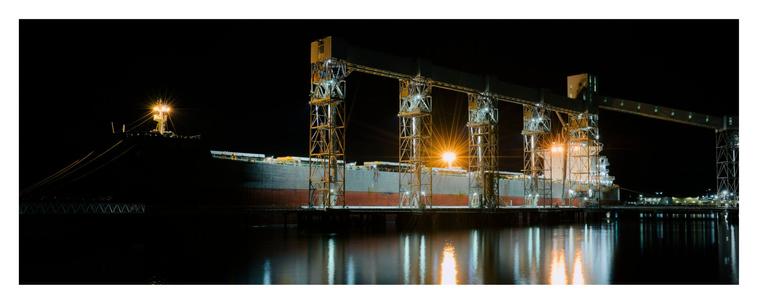 Bulk carrier loading grain at the terminal at night.