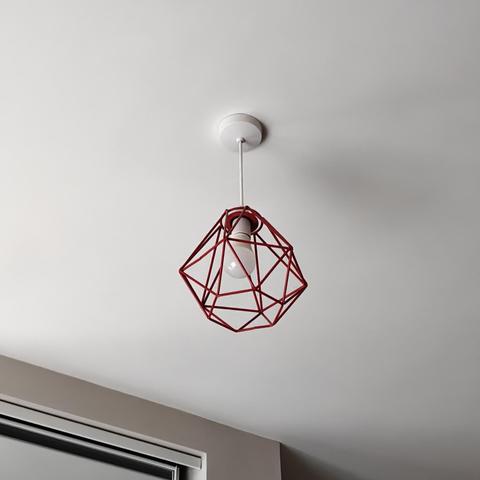 Photo of a lightbulb in a ceiling surrounded by a wire frame tetrahedron in red wire that does nothing to hide the light.