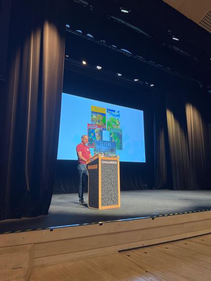 A speaker stands at a lectern.