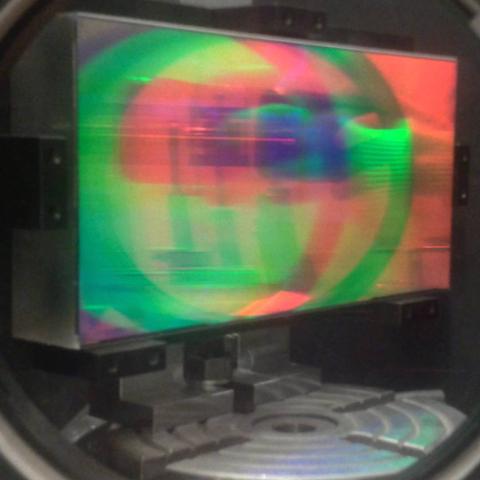 The surface of rectangular reflection grating splits the reflection of its surroundings into monochrome reflections offset from each other, the picture is dominated by the red and green reflections