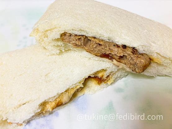 半分にカットされたランチパックの照り焼きハンバーグ味。柔らかなパンの中に、しっとりとしたハンバーグとツヤのある照り焼きソース、なめらかなマヨネーズが層になっている。