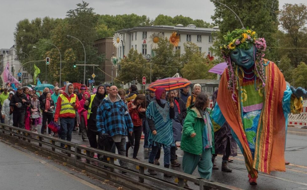 Foto von einem Aufzug mit übergroßer Front-Figur: Gaia, die Mutter Erde im bunten Gewand mit Blumenkranz im Haar