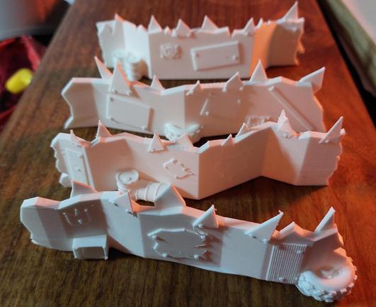 For very angly and very scrappy barriers that have got extra plates and pointy bits nailed on all across the board. Here and there are oil barrels or old wheels because they apparently make good barrier material as well.

Everything is printed in my hated white filament.