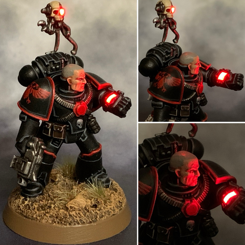 A 28mm scale miniature of an Inquisitor in black armour with a LED-powered wrist-mounted display and servo skull with LED bionic eye.
