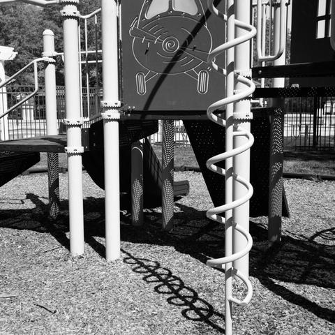A view of a children’s playground, casting shadows