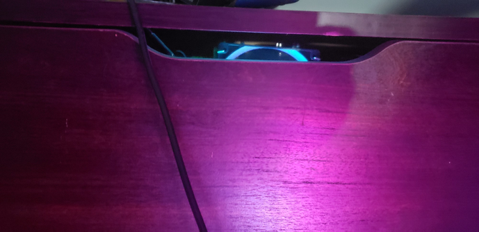 Computer fan being lit up by memory sticks peaking out of drawer opening