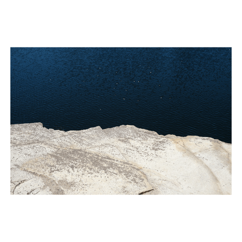 glint of sun sparkling on ripples below a rough outline stone platform