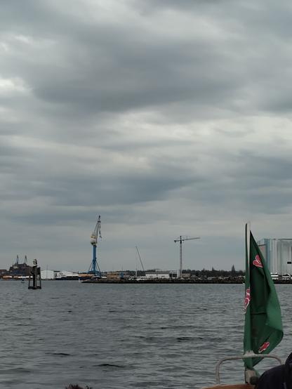 Photo of the City of Wismar taken from a boat in the Bay of Wismar. Picture is dominated by the prominent ship yard and it's cranes.