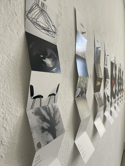 Mehrere Leporello an der Wand. Auf jedem sind vier Fotos zu sehen.