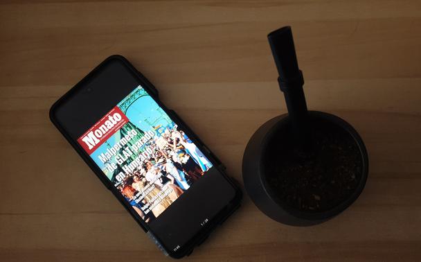 foto de mateujo kun yerba mate kaj Bombilla. tuj apud poŝtelefono kun pdf-kovrilo de Monato