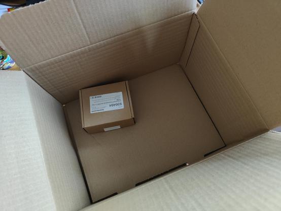 Fotos eines Versandkartons. Darin liegt ein viel kleinerer Karton mit dem bestellten Artikel. 
Die Verpackung des Artikels würde locker 30 Mal in den Versandkarton passen, wenn nicht noch öfter.