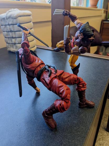 A Marvel Legends Hand Ninja leaning back attempting to block a leaping attack from Wolverine
